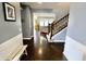 The light-filled foyer features a staircase and dark hardwood flooring that leads into the living area at 5473 Forest Glen Dr, Brownsburg, IN 46112