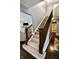 Elegant staircase with carpeted steps and a dark wood railing, transitioning to the upper level at 5473 Forest Glen Dr, Brownsburg, IN 46112
