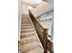 Carpeted staircase with a wooden banister, adjacent to built in storage at 5473 Forest Glen Dr, Brownsburg, IN 46112