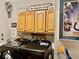 Laundry room with modern black washer and dryer with brown cabinets and sports themed decor at 5586 S 200 E, Franklin, IN 46131