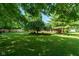 Expansive backyard with lush lawn, mature trees offering shade, and a peaceful setting at 5631 Shelby St, Indianapolis, IN 46227