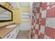 Cozy bathroom with a tiled floor, single sink vanity, and shower with a red checkered curtain at 5631 Shelby St, Indianapolis, IN 46227
