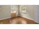 Well-lit bedroom with two windows, wood-look flooring, and a spacious closet at 5631 Shelby St, Indianapolis, IN 46227