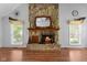 Detailed stone fireplace with wooden mantle, mirror, and decorative accents in bright living space at 5631 Shelby St, Indianapolis, IN 46227