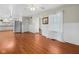 Open-concept living room with stainless steel fridge, hardwood floors, and adjacent kitchen at 5631 Shelby St, Indianapolis, IN 46227