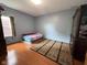Bedroom with wood floors, large rug, a bed and decorative wood cabinet at 621 Appleseed Way, Indianapolis, IN 46217