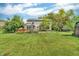 Large backyard featuring a well-maintained lawn, mature trees, and a private hot tub area at 6329 Whitaker Farms Dr, Indianapolis, IN 46237