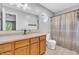 Bathroom features a white sink, wooden cabinets, a mirror, and patterned shower curtains at 6329 Whitaker Farms Dr, Indianapolis, IN 46237