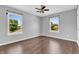 Bright bedroom featuring two windows, hardwood floors, and a ceiling fan at 6329 Whitaker Farms Dr, Indianapolis, IN 46237