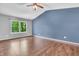 Spacious bedroom featuring a large window, hardwood floors, and ceiling fan at 6329 Whitaker Farms Dr, Indianapolis, IN 46237