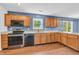 This Kitchen boasts wooden cabinets, stainless steel appliances, and natural light from the adjacent sliding glass door at 6329 Whitaker Farms Dr, Indianapolis, IN 46237