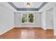Well-lit room with tray ceiling, wood floors, and large windows at 6329 Whitaker Farms Dr, Indianapolis, IN 46237