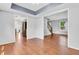 Open concept living area with hardwood floors, tray ceiling, and adjoining kitchen at 6329 Whitaker Farms Dr, Indianapolis, IN 46237