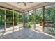 Bright sunroom with tile floor and glass doors offering panoramic views of the lush backyard at 6329 Whitaker Farms Dr, Indianapolis, IN 46237