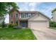 Charming two-story home featuring a well-manicured lawn, blue door, and a mix of brick and siding at 6562 Quail Run, Fishers, IN 46038