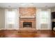 Close up on brick fireplace, featuring a white mantel and window to either side at 6562 Quail Run, Fishers, IN 46038