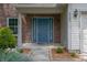 Close-up of the front door, showcasing a blue door, brick facade, and landscaped walkway at 6562 Quail Run, Fishers, IN 46038