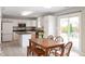 Bright kitchen with white cabinets, island, and a dining area with access to the patio at 6562 Quail Run, Fishers, IN 46038