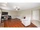 Cozy living room featuring wood floors, a ceiling fan, comfortable seating, and a TV at 6562 Quail Run, Fishers, IN 46038