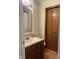 Bathroom featuring wood cabinets, a mirror and wood flooring at 6932 Deerbrook Ct, Indianapolis, IN 46214