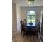 Charming dining area featuring a large arched window, hardwood floors, and a stylish chandelier at 6932 Deerbrook Ct, Indianapolis, IN 46214