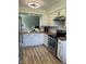 Stylish kitchen with white cabinets, hardwood counters, stainless steel appliances, and laminate flooring at 6932 Deerbrook Ct, Indianapolis, IN 46214