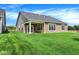 Backyard with green lawn, covered patio, and newly constructed home at 7205 Rose Hill Ave, Brownsburg, IN 46112