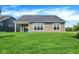 Expansive backyard with lush green grass, a covered patio, and beautiful exterior siding at 7205 Rose Hill Ave, Brownsburg, IN 46112
