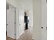 Hallway view leading to the kitchen with stainless steel refrigerator and dark wood cabinets at 7205 Rose Hill Ave, Brownsburg, IN 46112