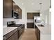 Well-equipped kitchen with stainless steel appliances, dark wood cabinets, and a kitchen island at 7205 Rose Hill Ave, Brownsburg, IN 46112