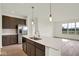 Open kitchen features an island with a sink, stainless steel appliances, and hardwood floors at 7205 Rose Hill Ave, Brownsburg, IN 46112