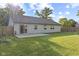 Wide shot of backyard, complete with lawn, patio, windows, and sliding door at 7239 N Orchard Dr, Indianapolis, IN 46236