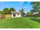 Large backyard with a well-maintained lawn, privacy fence, and an access door to the home at 7239 N Orchard Dr, Indianapolis, IN 46236