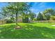 Picturesque backyard featuring a fire pit, privacy fence, mature trees, and a storage shed at 7239 N Orchard Dr, Indianapolis, IN 46236