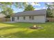 Backyard shot with green lawn, fire pit and small patio at 7239 N Orchard Dr, Indianapolis, IN 46236