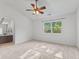 Bedroom with neutral paint, fan, carpet, large window, and ensuite bathroom at 7239 N Orchard Dr, Indianapolis, IN 46236