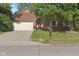 Charming brick home with a well-maintained lawn, mature tree, and red front door at 7239 N Orchard Dr, Indianapolis, IN 46236