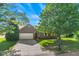Charming brick home with an attached two-car garage, long driveway, lush lawn, and mature trees at 7239 N Orchard Dr, Indianapolis, IN 46236