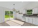 Bright eat-in kitchen with white cabinets, stainless appliances, access to backyard, and lots of natural light at 7239 N Orchard Dr, Indianapolis, IN 46236