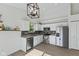 Modern kitchen with stainless steel appliances, white cabinets, stylish lighting, and a window view at 7239 N Orchard Dr, Indianapolis, IN 46236