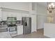 Well-lit kitchen featuring stainless appliances, white cabinets and a window with wooded view at 7239 N Orchard Dr, Indianapolis, IN 46236