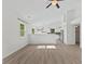 Living room with vaulted ceiling features contemporary light fixture and vinyl plank flooring at 7239 N Orchard Dr, Indianapolis, IN 46236