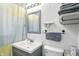 Well-lit bathroom showcasing a modern vanity, a neutral shower curtain, and a functional toilet at 7307 Twin Beech Dr, Indianapolis, IN 46226