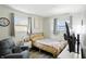 Cozy bedroom featuring natural light from two windows, a brass bed, and a comfortable accent chair at 7307 Twin Beech Dr, Indianapolis, IN 46226