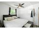 Bright bedroom featuring a cozy bed, ceiling fan, natural light, and a minimalist decor with convenient clothing rack at 7307 Twin Beech Dr, Indianapolis, IN 46226