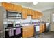Well-lit kitchen featuring wooden cabinets, stainless steel appliances, and a sink with lavender countertops at 7307 Twin Beech Dr, Indianapolis, IN 46226