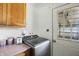 Convenient laundry area featuring a modern washer, adjacent countertop space, and a view to the outside at 7307 Twin Beech Dr, Indianapolis, IN 46226