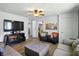 Comfortable living room featuring plush seating, hardwood floors, ceiling fan, with a large screen television at 7307 Twin Beech Dr, Indianapolis, IN 46226
