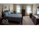 This is a bedroom with neutral carpet, light walls and a beautiful bed and furniture at 7334 Fairwood Cir, Indianapolis, IN 46256