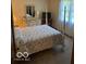 Bedroom with quilt bed cover and white furniture in a carpeted, small room at 7334 Fairwood Cir, Indianapolis, IN 46256